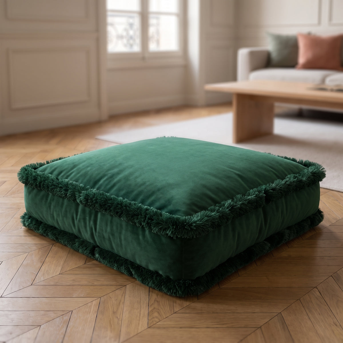 Coussin de sol en velours vert sapin à franges, posé sur un parquet