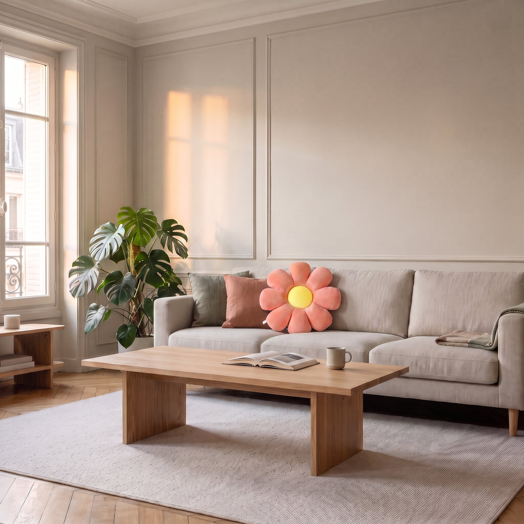 Coussin fleur rose a huit petales pose sur un canape clair dans un salon haussmannien