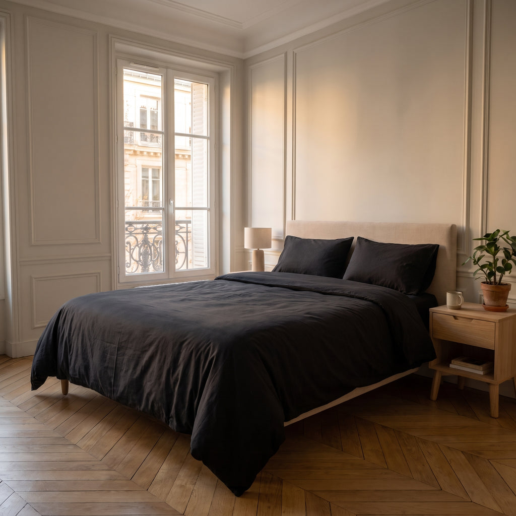 Housse de couette unie noir sur un lit dans une chambre lumineuse