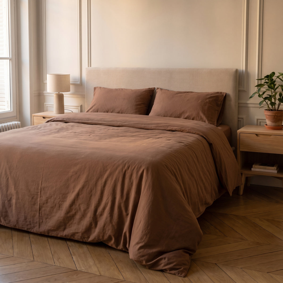 Housse de couette unie marron sur un lit dans une chambre lumineuse