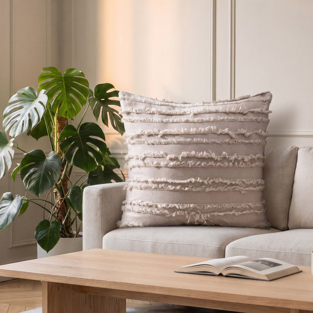 Housse de coussin bohème beige à bandes effilées sur un canapé clair