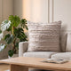 Housse de coussin bohème beige à bandes effilées sur un canapé clair