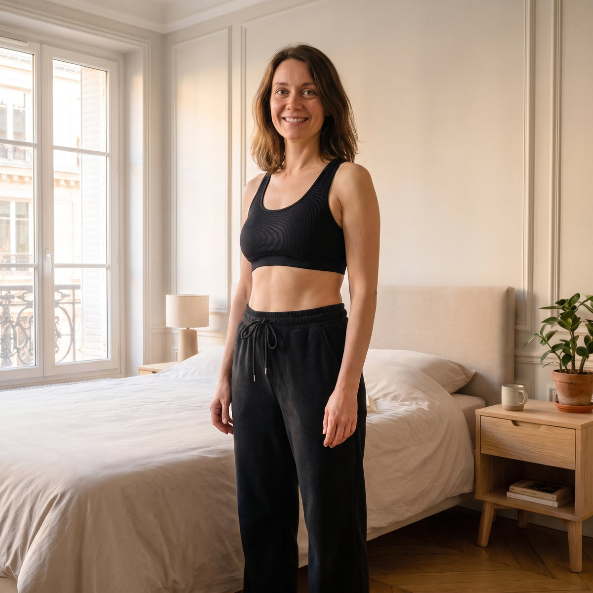 Jogging femme grande taille noir porté dans un salon lumineux Image