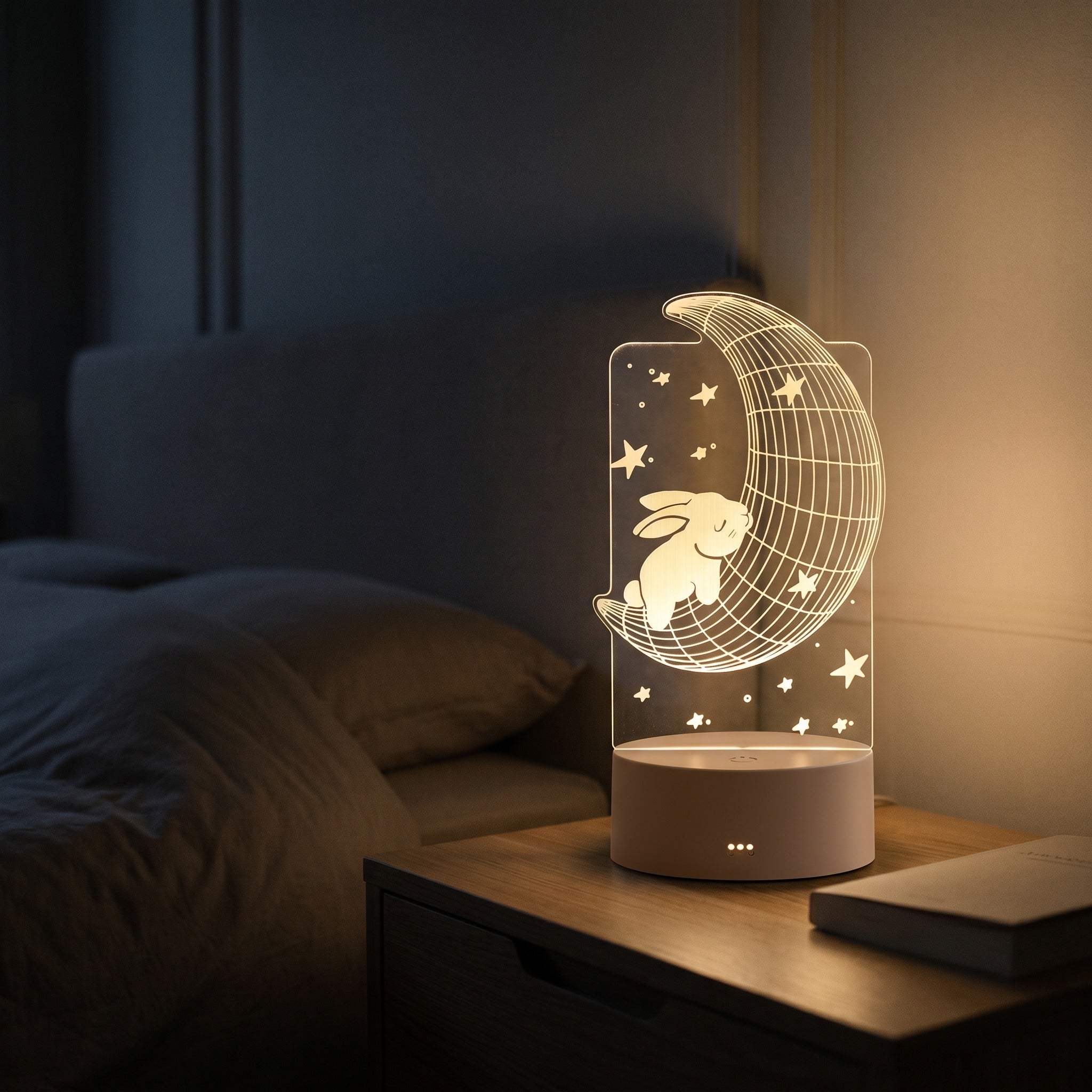 Lampe veilleuse 3D en acrylique motif lune allumée sur une table de chevet le soir Image