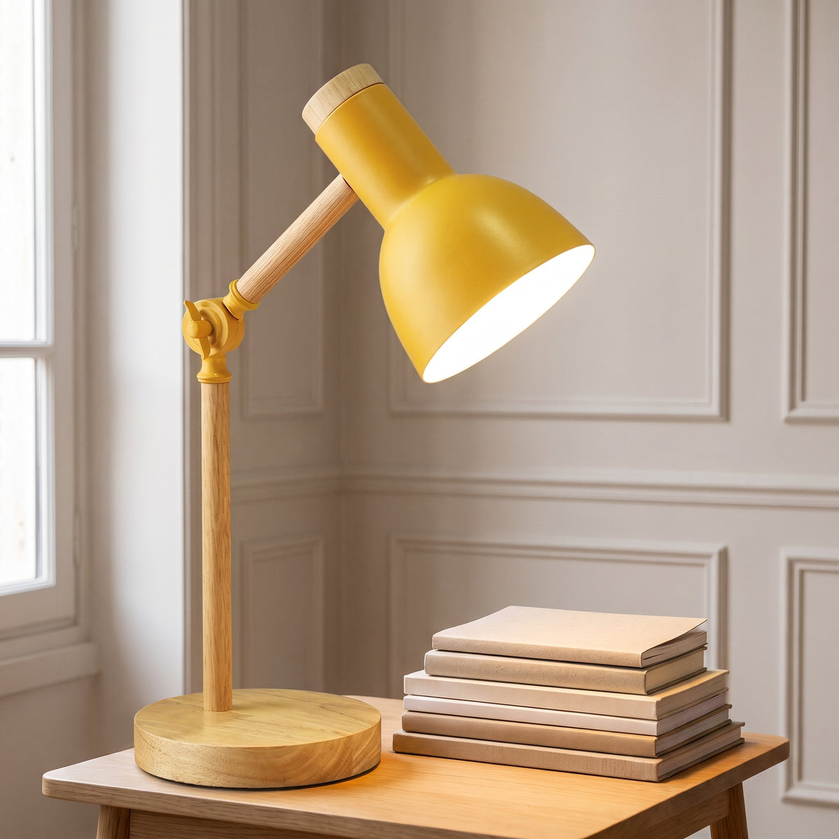Lampe de bureau pliante jaune près d'une pile de livres