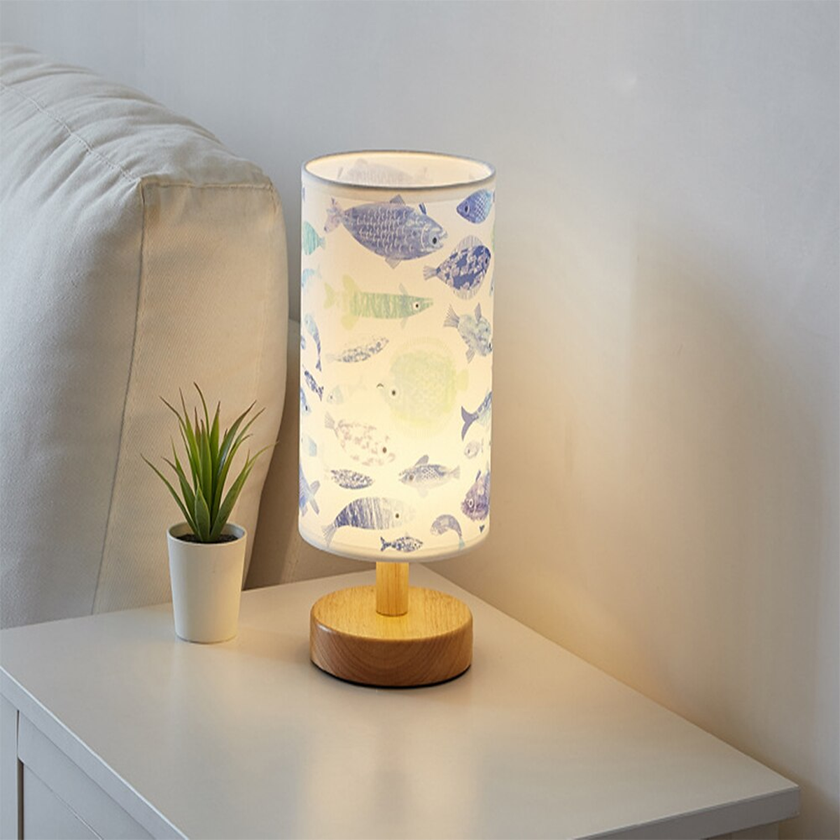 Lampe de chevet allumée avec abat-jour à motifs poissons