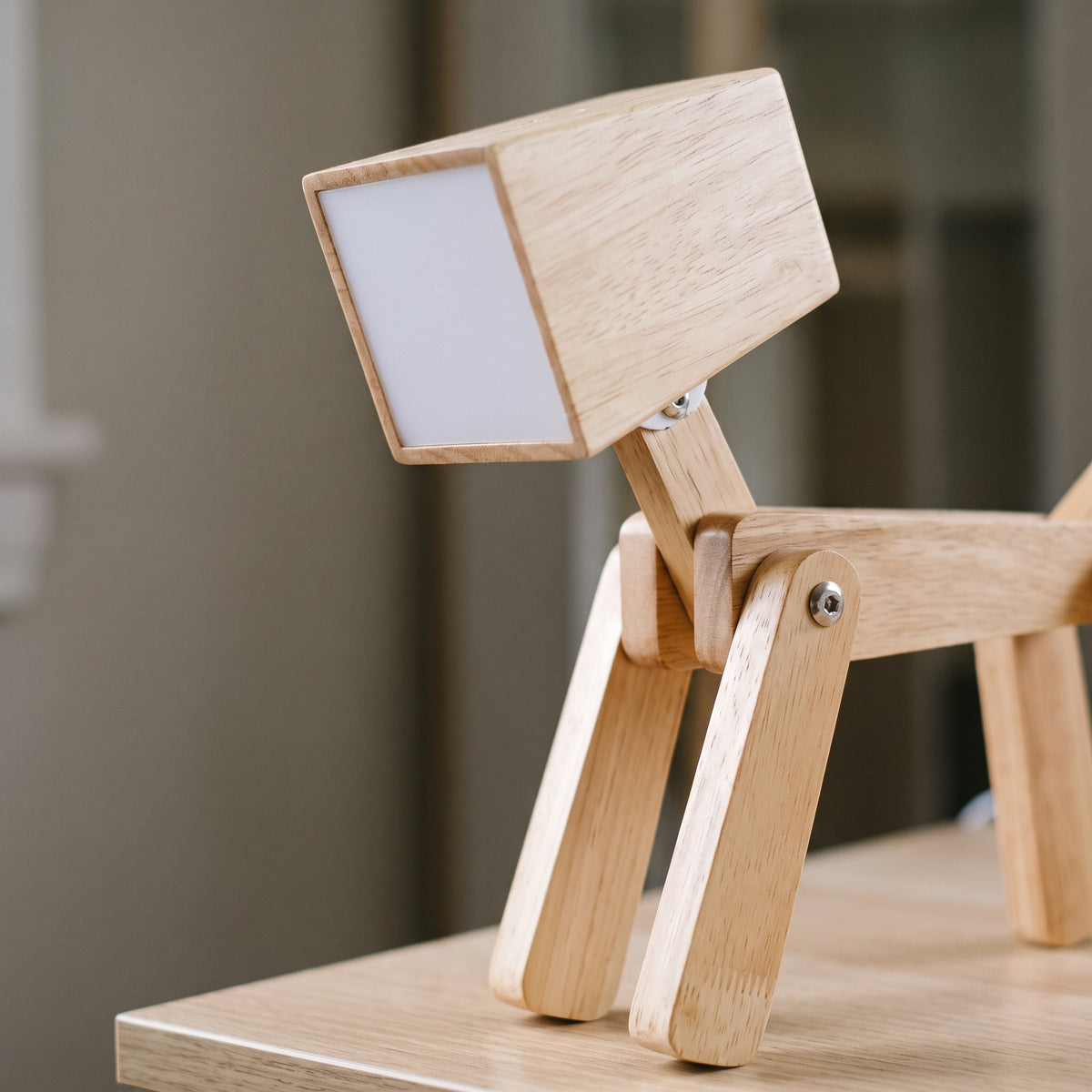 Détail de la tête lumineuse et des articulations de la lampe chien en bois