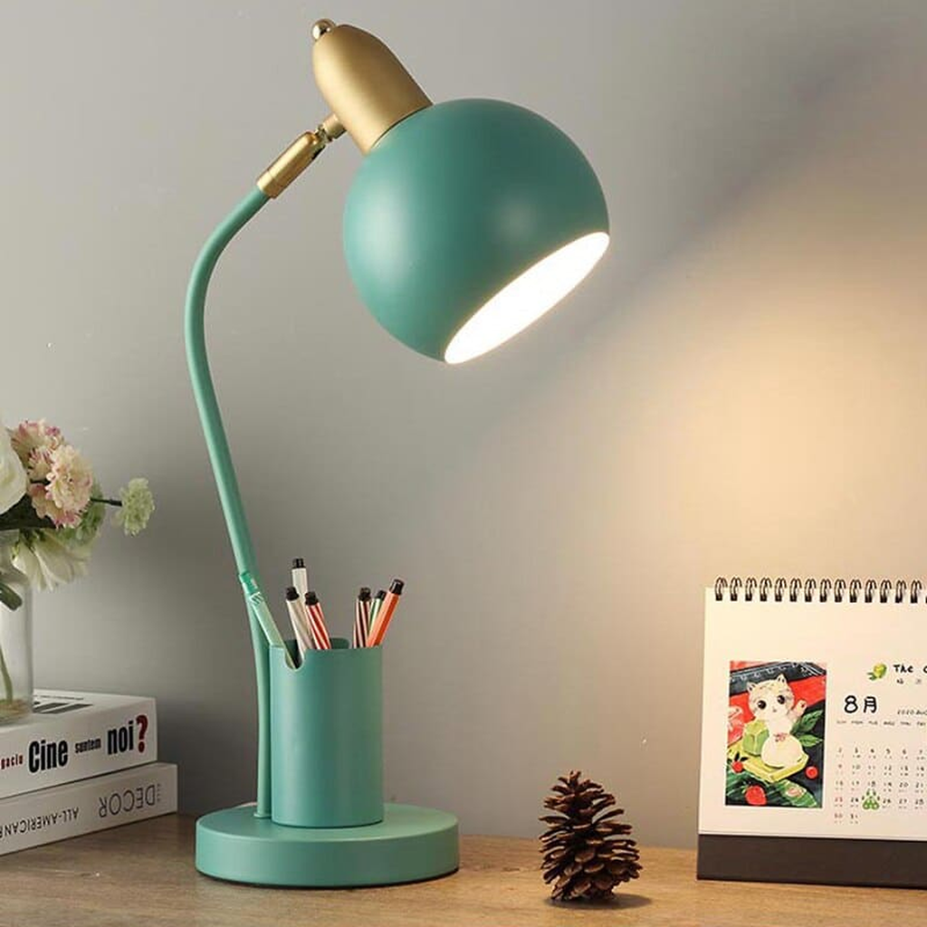 Lampe de bureau à pot à crayons, coloris vert de gris, allumée sur un bureau en bois