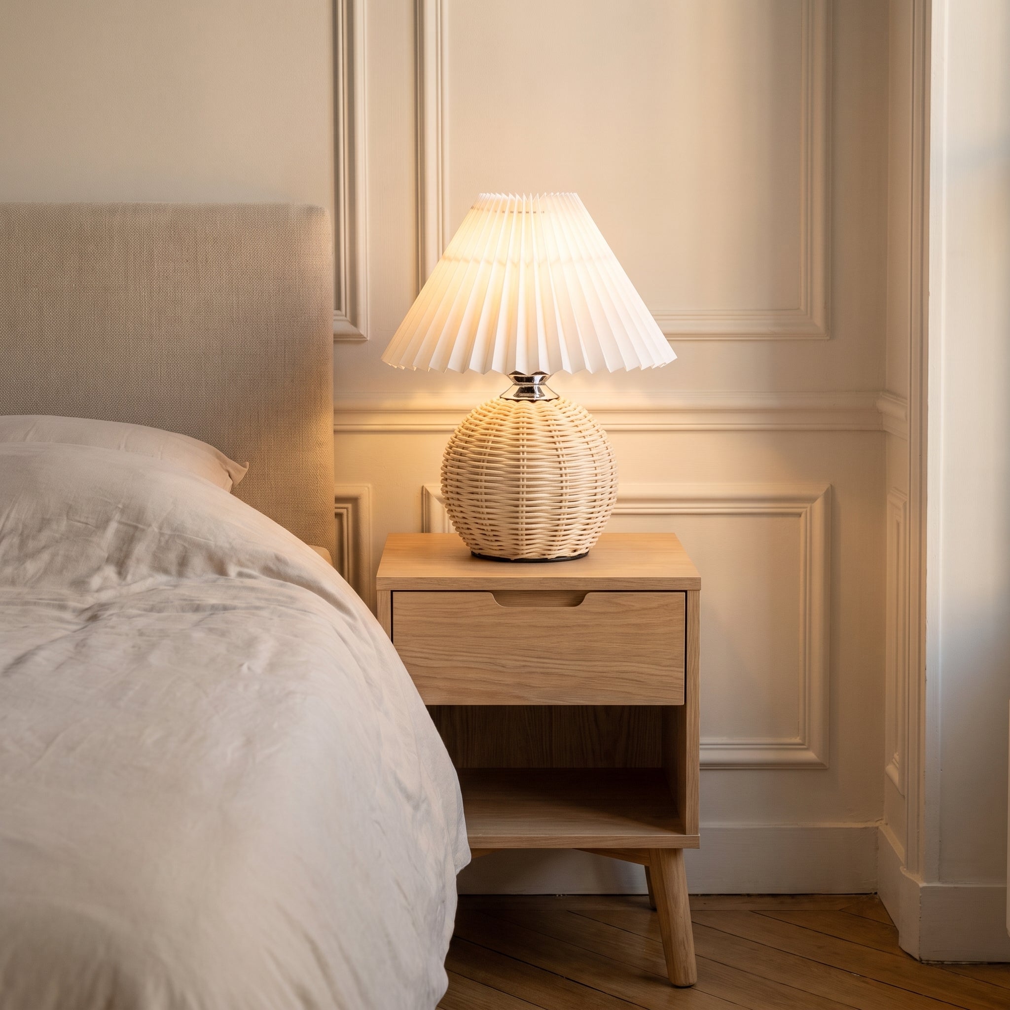 Lampe en rotin allumée sur une table de chevet Image