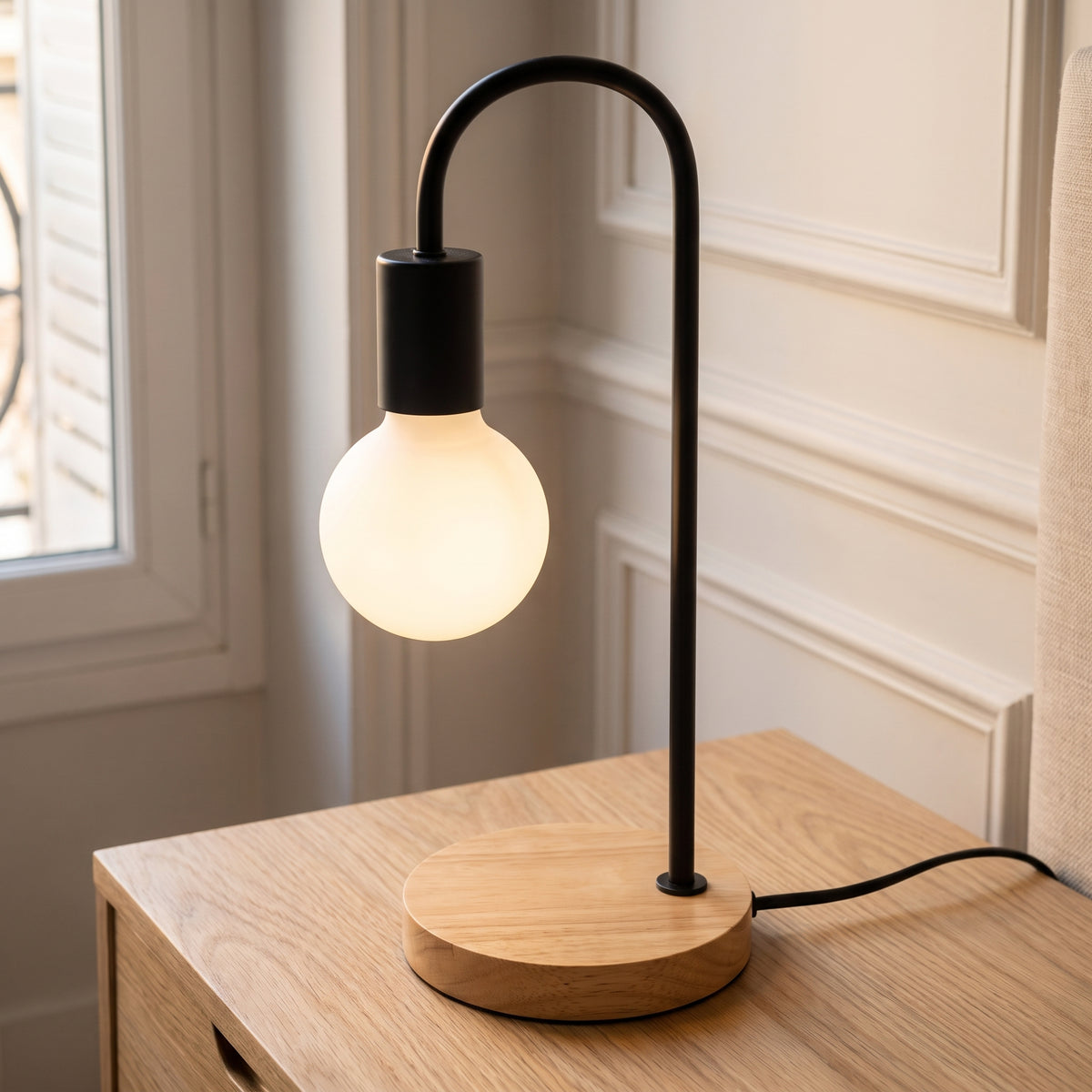 Gros plan sur l'arc de métal noir, la douille et le globe dépoli de la lampe Edison Image