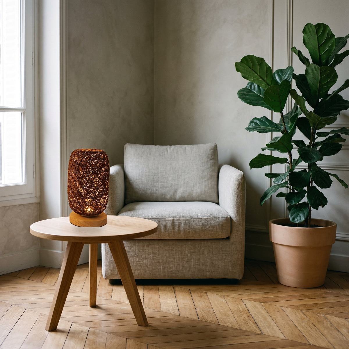 Lampe de table effet rotin marron près d’un fauteuil de lecture