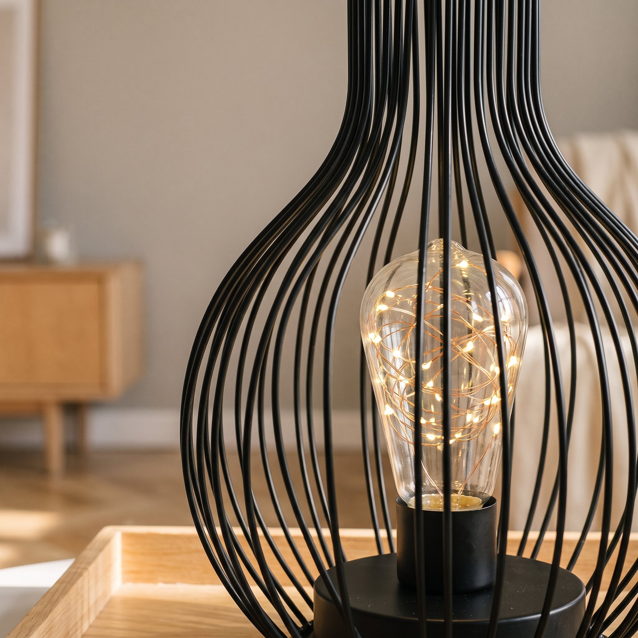 Détail de la cage en fil de fer et de l'ampoule à filaments de la lampe de table Image