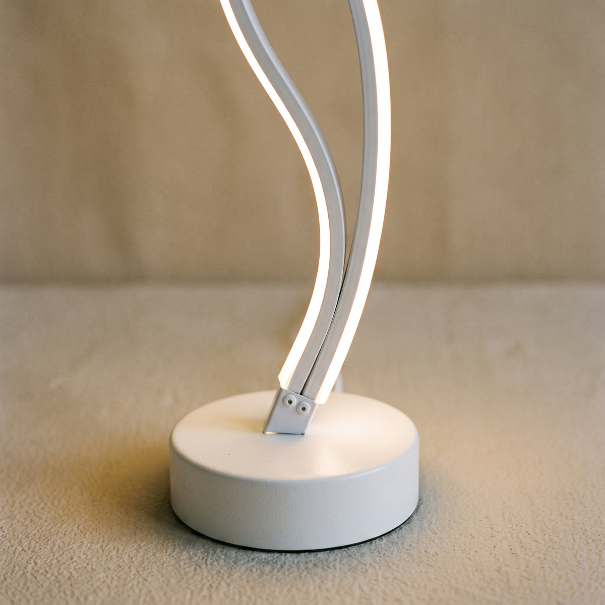 Détail du socle rond et des deux courbes lumineuses de la lampe spirale modèle 1
