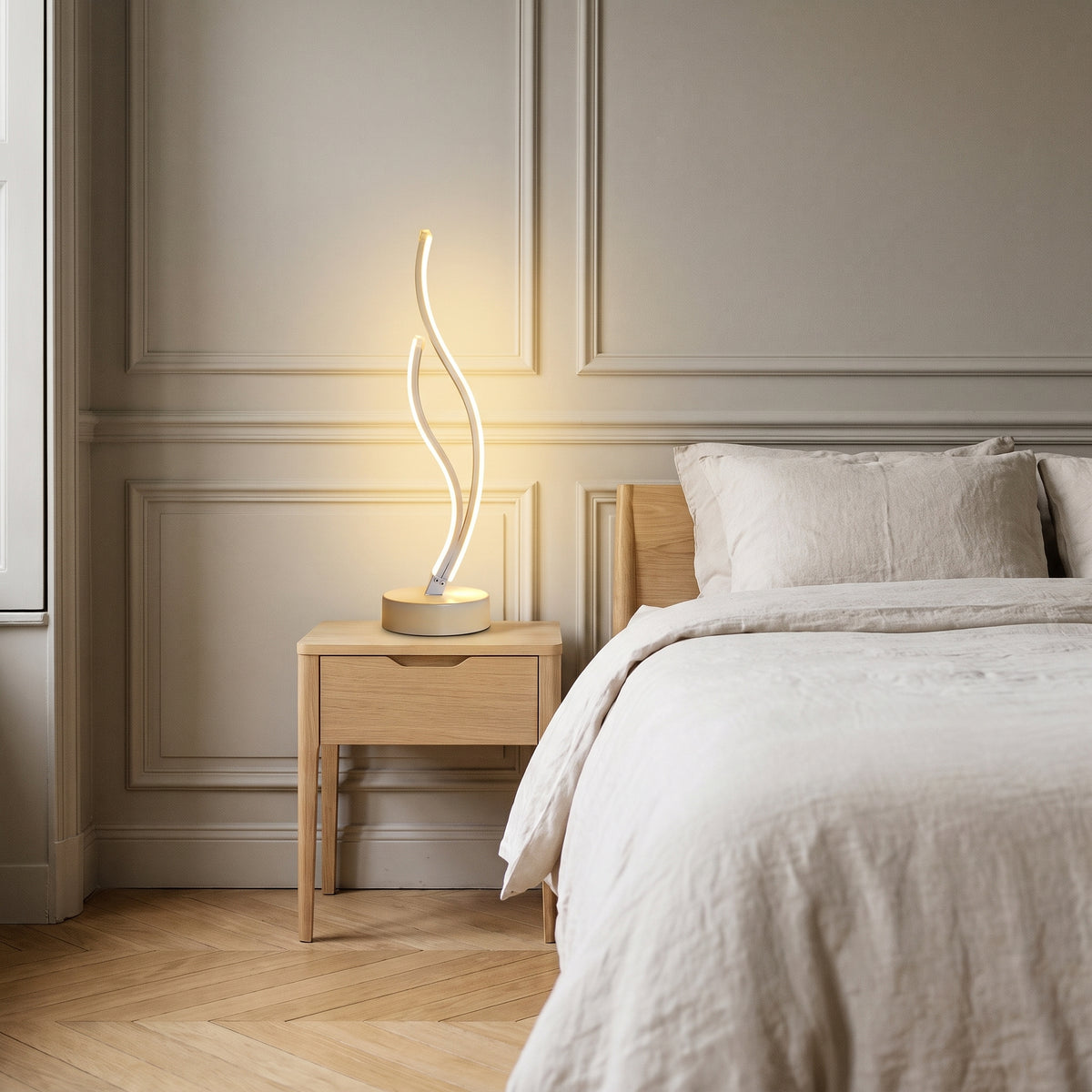 Lampe de chevet LED spirale modèle 1 à lumière jaune, posée près d’un lit