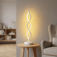 Lampe LED spirale modèle 2 à lumière jaune près d’un fauteuil de lecture