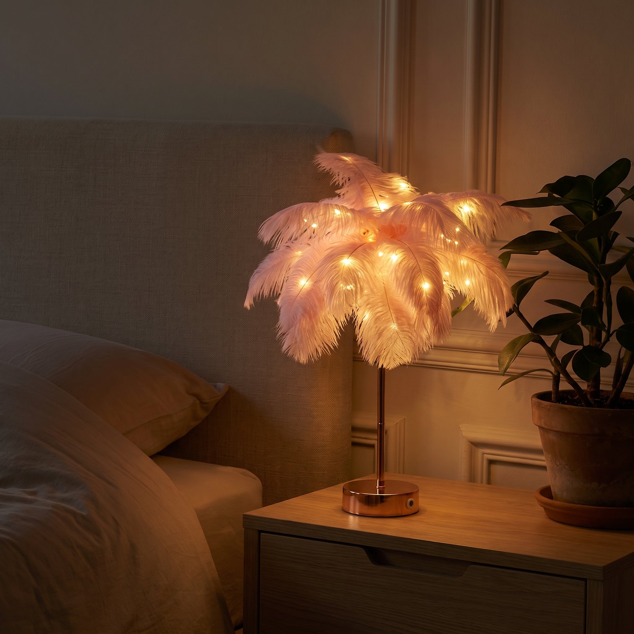 Lampe à plumes roses allumée sur une table de chevet, le soir Image
