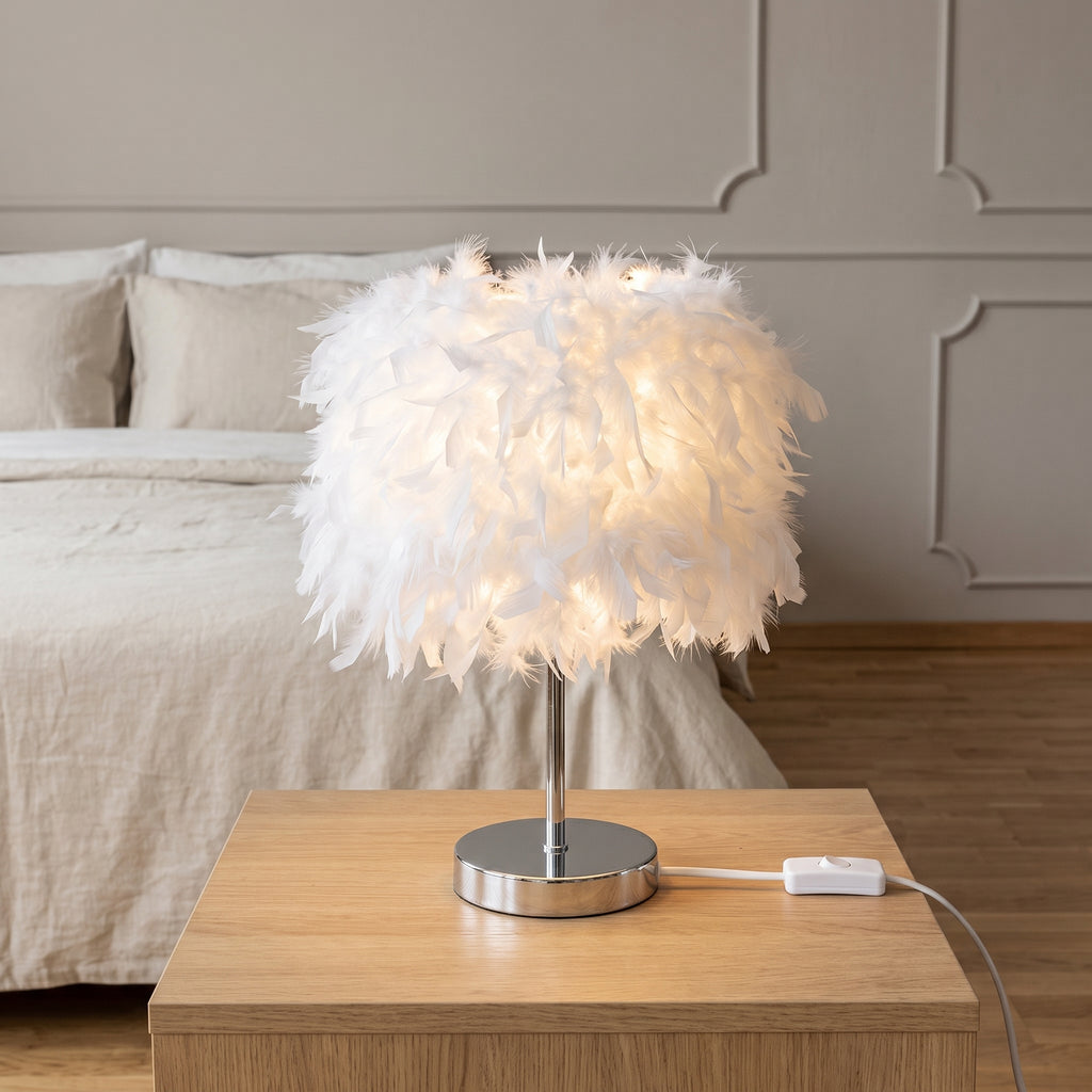 Lampe à plumes blanche sur une table de chevet avec son interrupteur