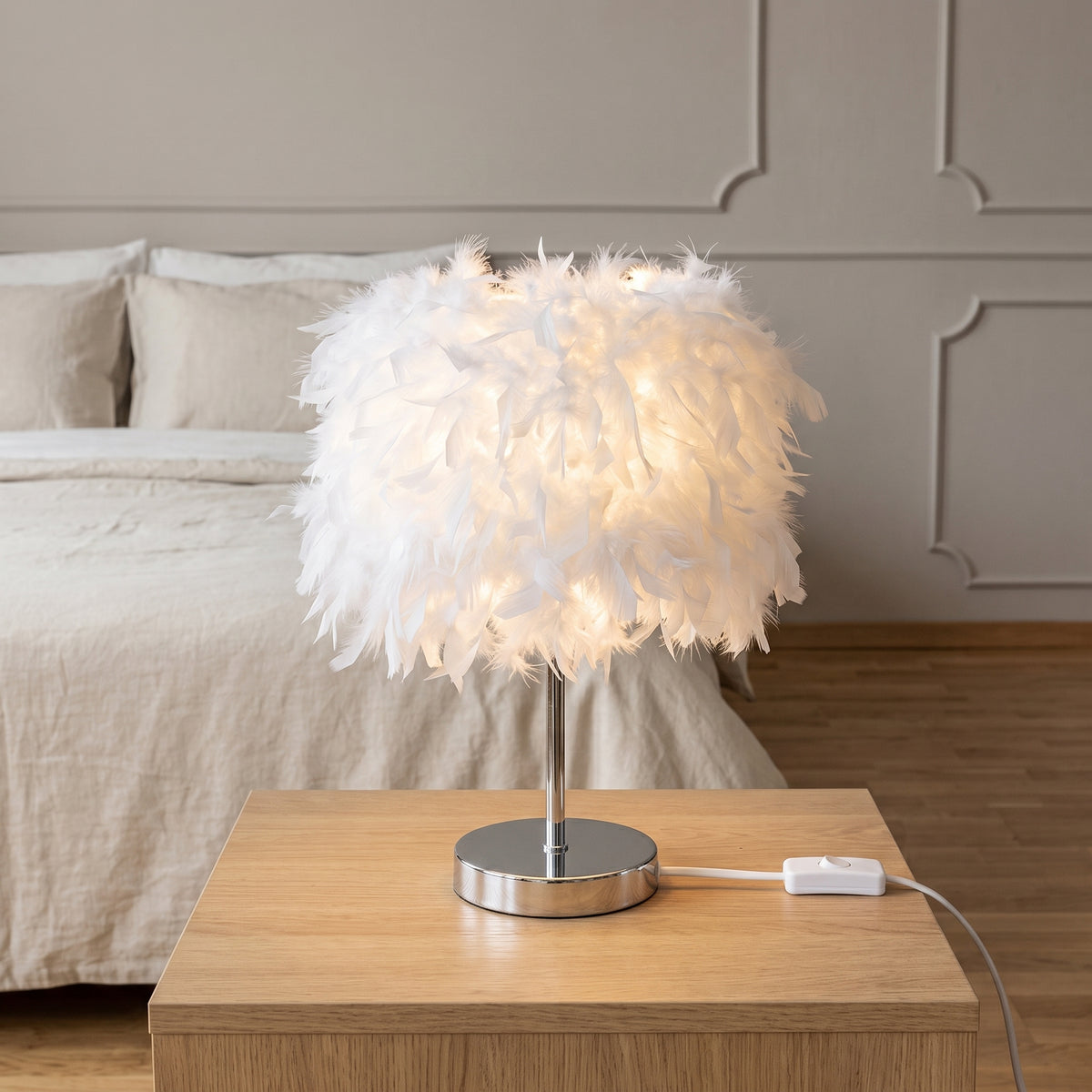Lampe à plumes blanche sur une table de chevet avec son interrupteur