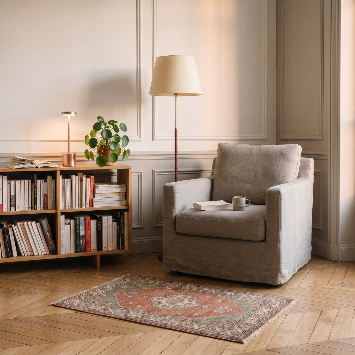 Lampe de table tactile en métal rosé allumée près d'un fauteuil de lecture