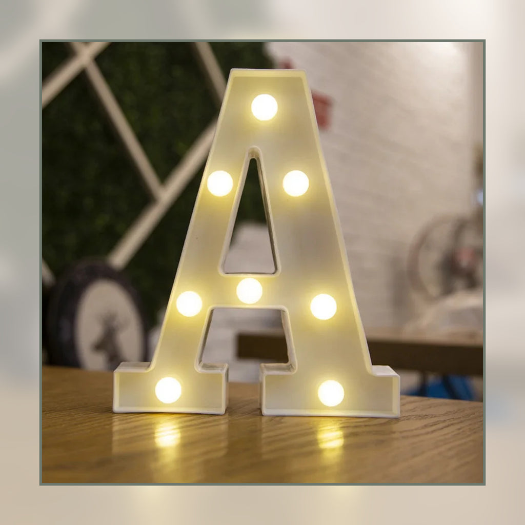 Lettre lumineuse LED A blanche allumée et posée sur un meuble