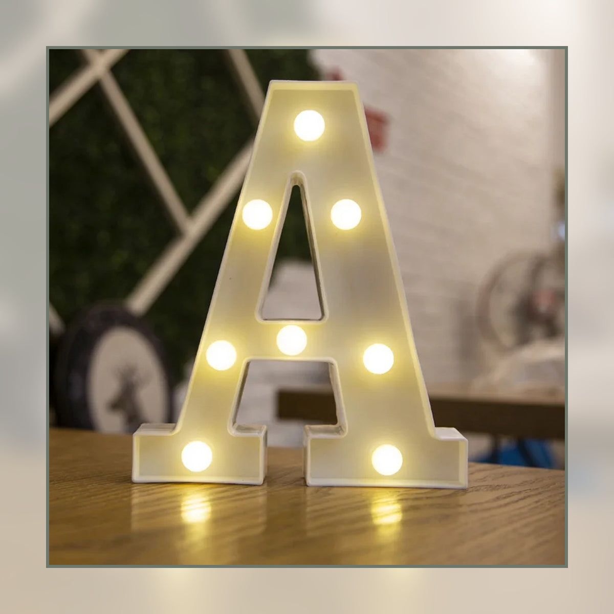 Lettre lumineuse LED A blanche allumée et posée sur un meuble