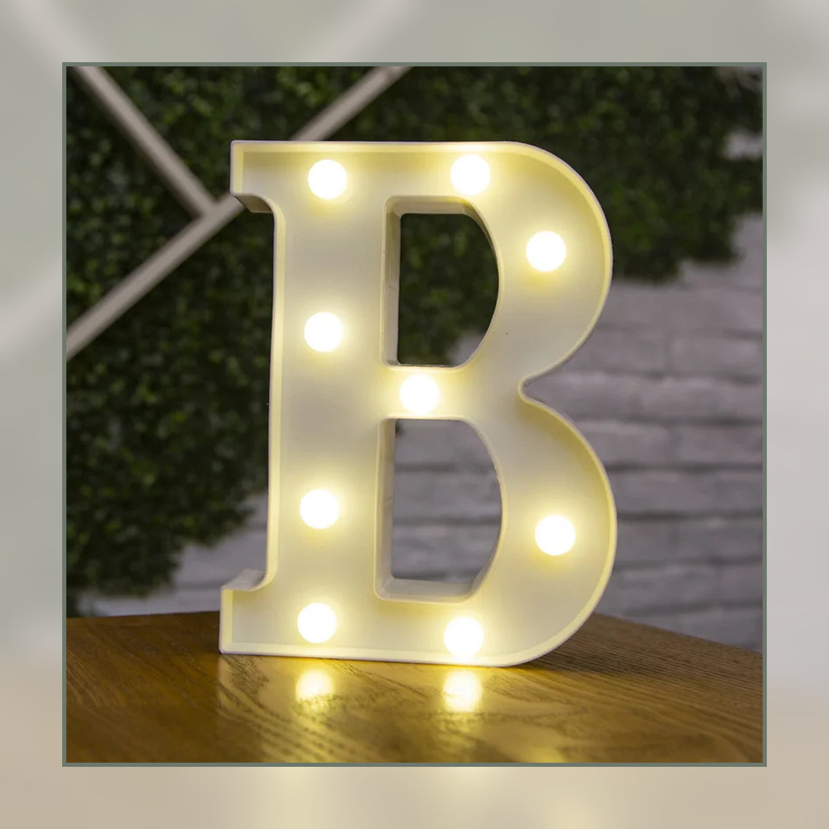 Lettre lumineuse LED B blanche allumée et posée sur un meuble