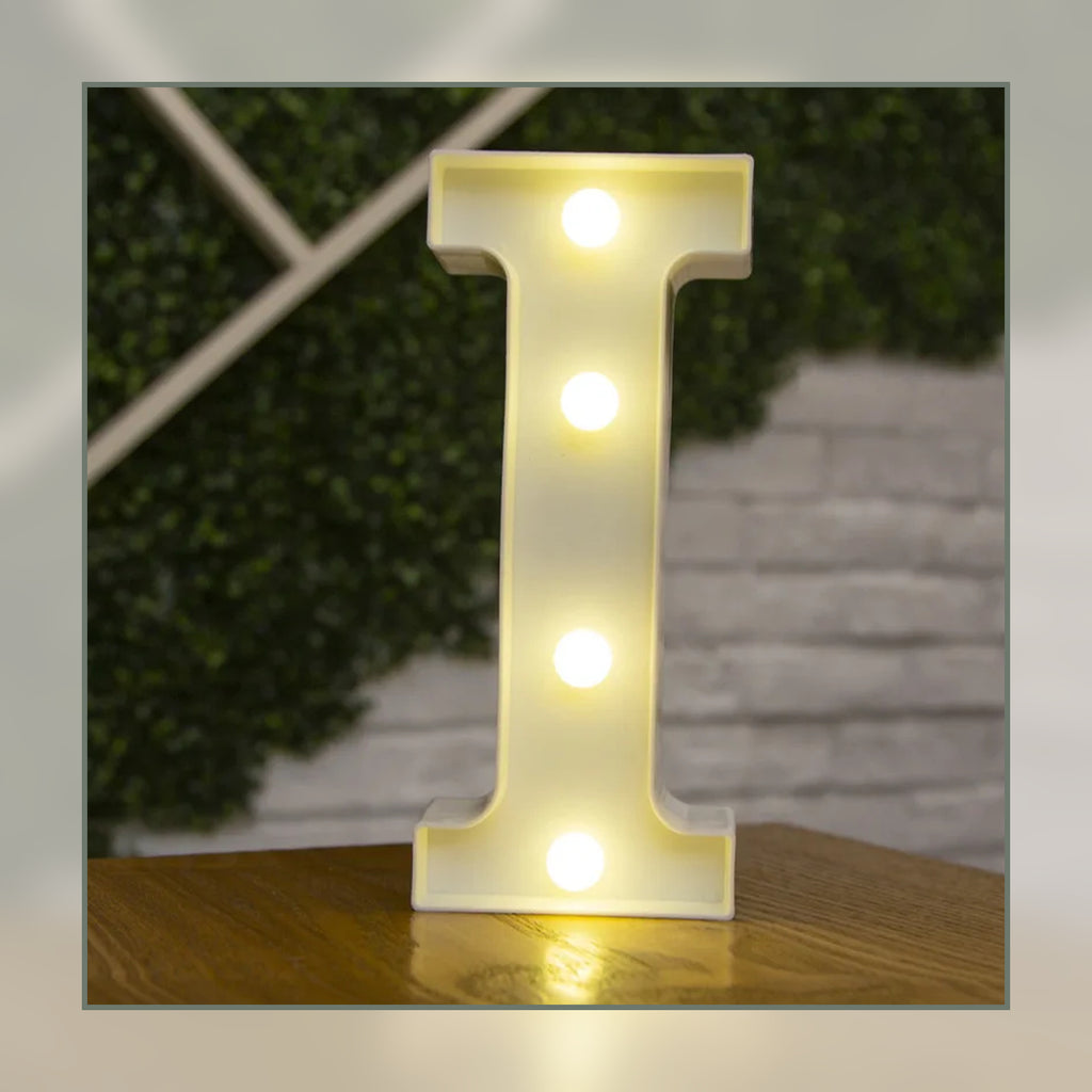 Lettre lumineuse LED I blanche allumée et posée sur un meuble