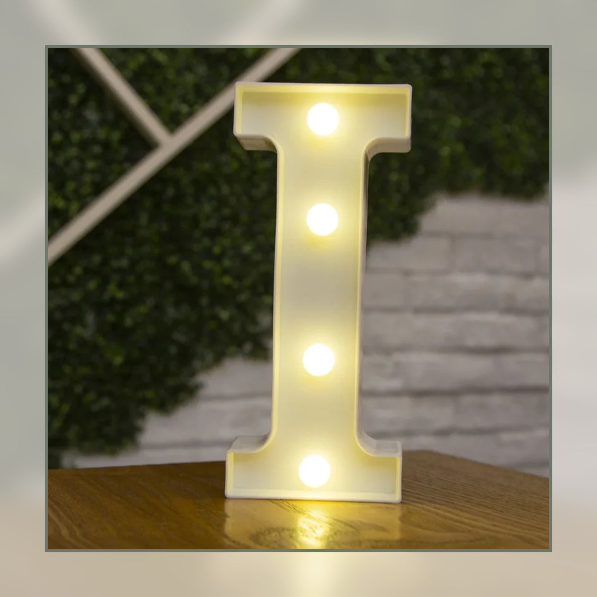 Lettre lumineuse LED I blanche allumée et posée sur un meuble