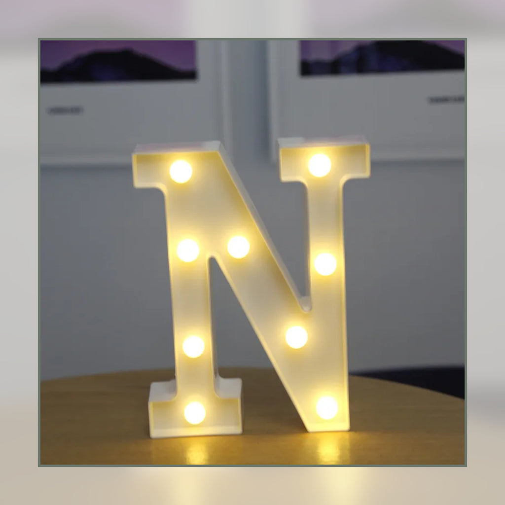 Lettre lumineuse LED N blanche allumée et posée sur un meuble