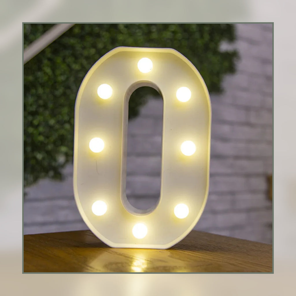 Lettre lumineuse LED O blanche allumée et posée sur un meuble