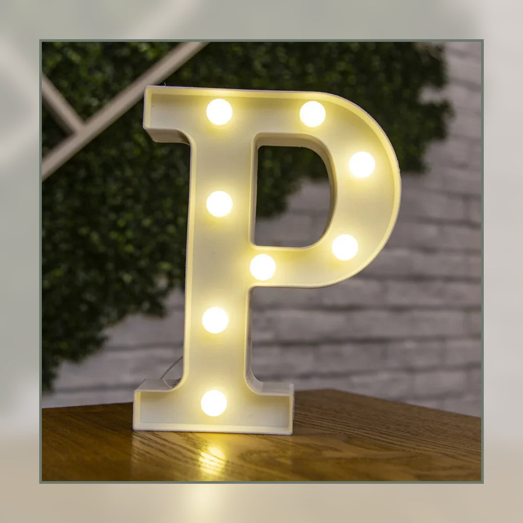 Lettre lumineuse LED P blanche allumée et posée sur un meuble