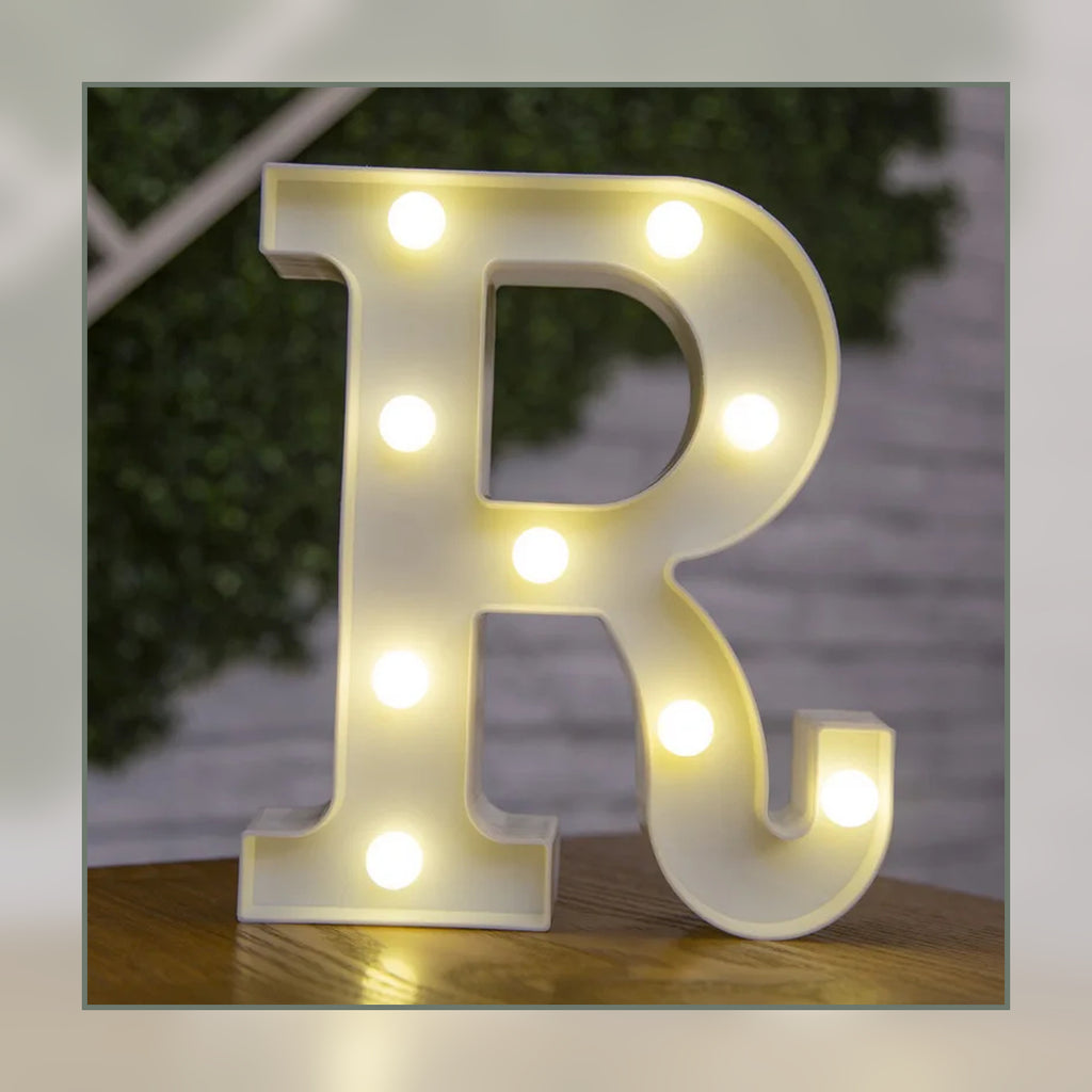 Lettre lumineuse LED R blanche allumée et posée sur un meuble