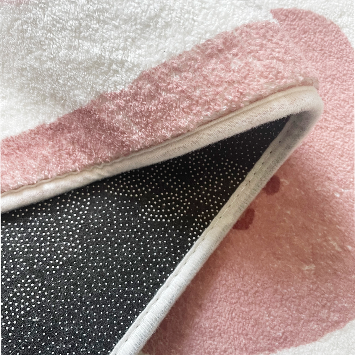 Détail de la texture et du dessous antidérapant du tapis long enfant