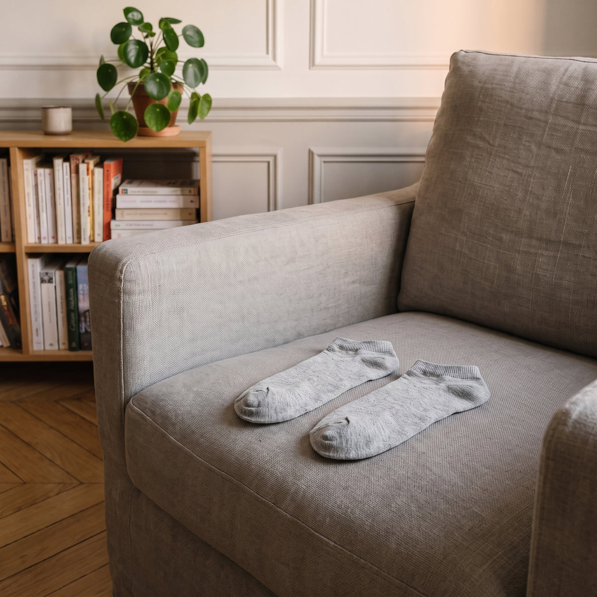 Paire de chaussettes grises basses posée à plat sur un fauteuil. Image