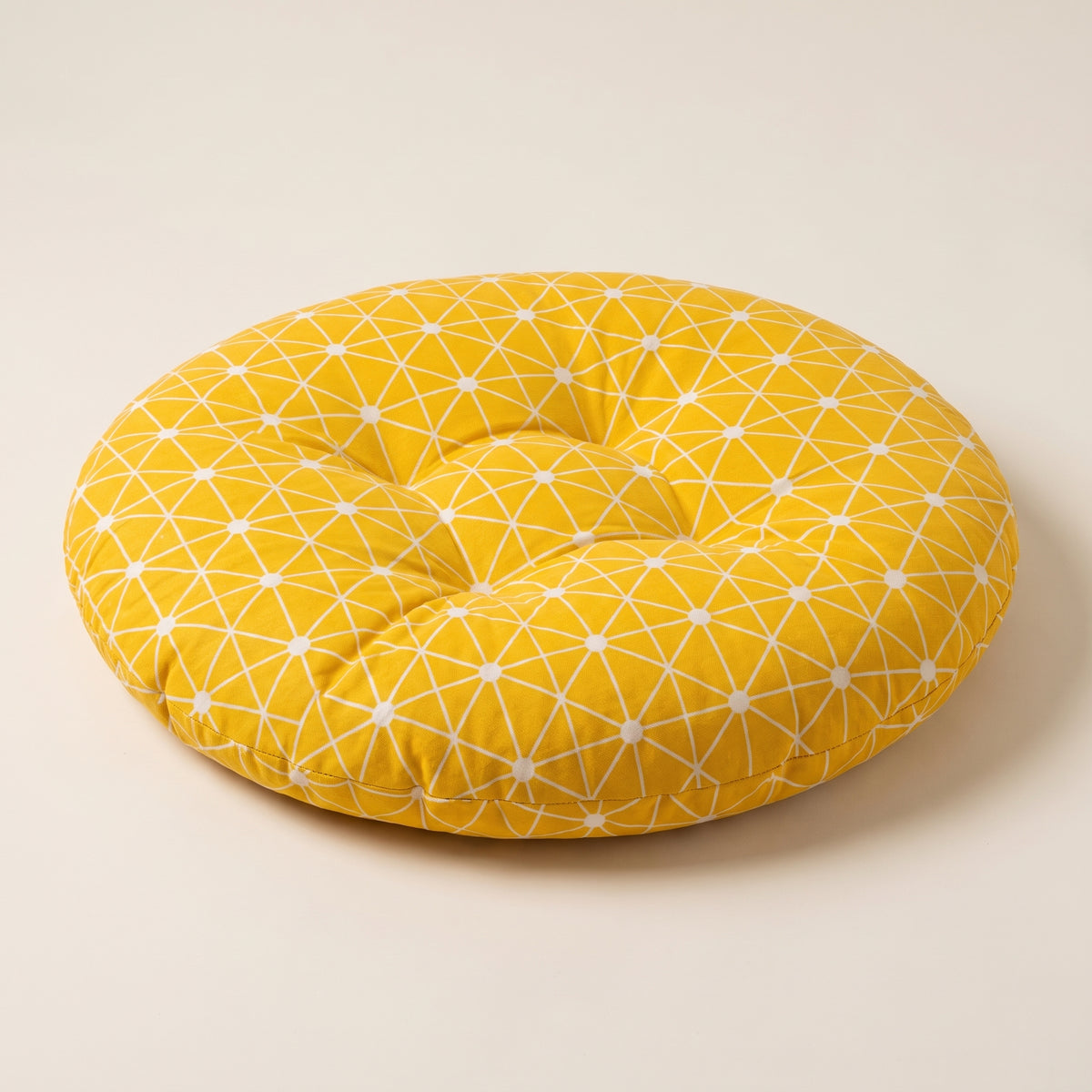 Coussin de sol Étoiles moutarde, packshot sur fond écru