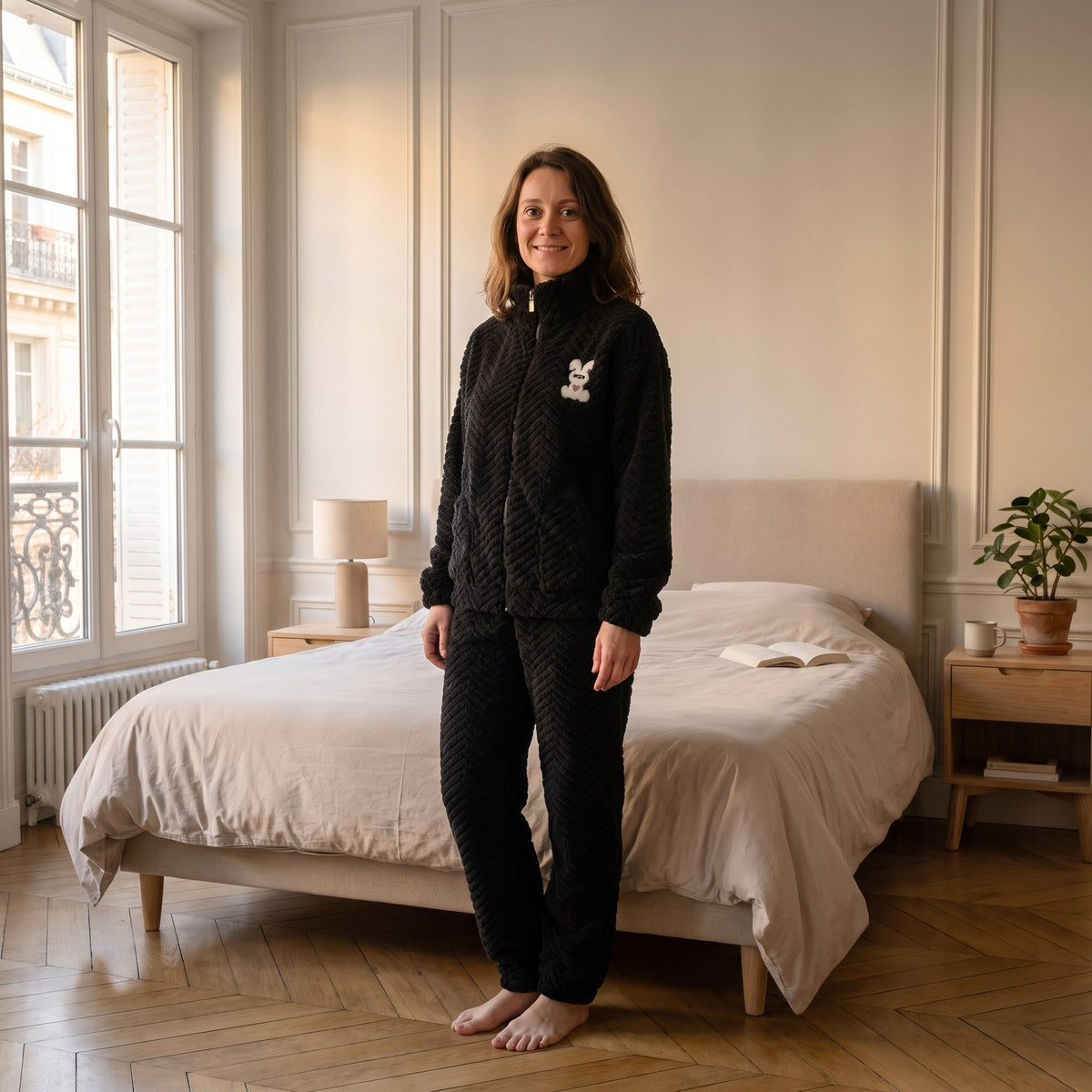 Femme en pyjama polaire noir à col montant zippé, écusson lapin