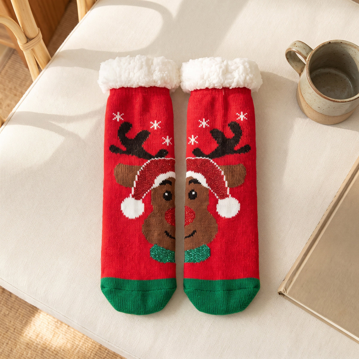 Chaussettes de Noël rouges à renne au bonnet posées à plat sur le canapé