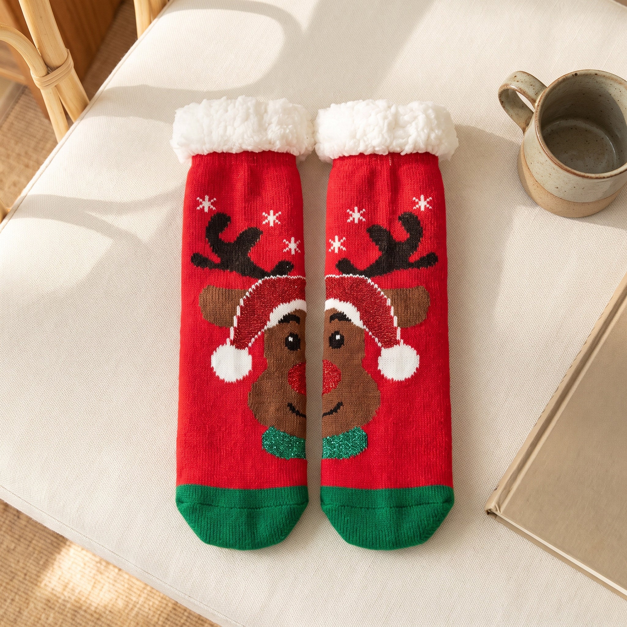 Chaussettes de Noël rouges à renne au bonnet posées à plat sur le canapé Image