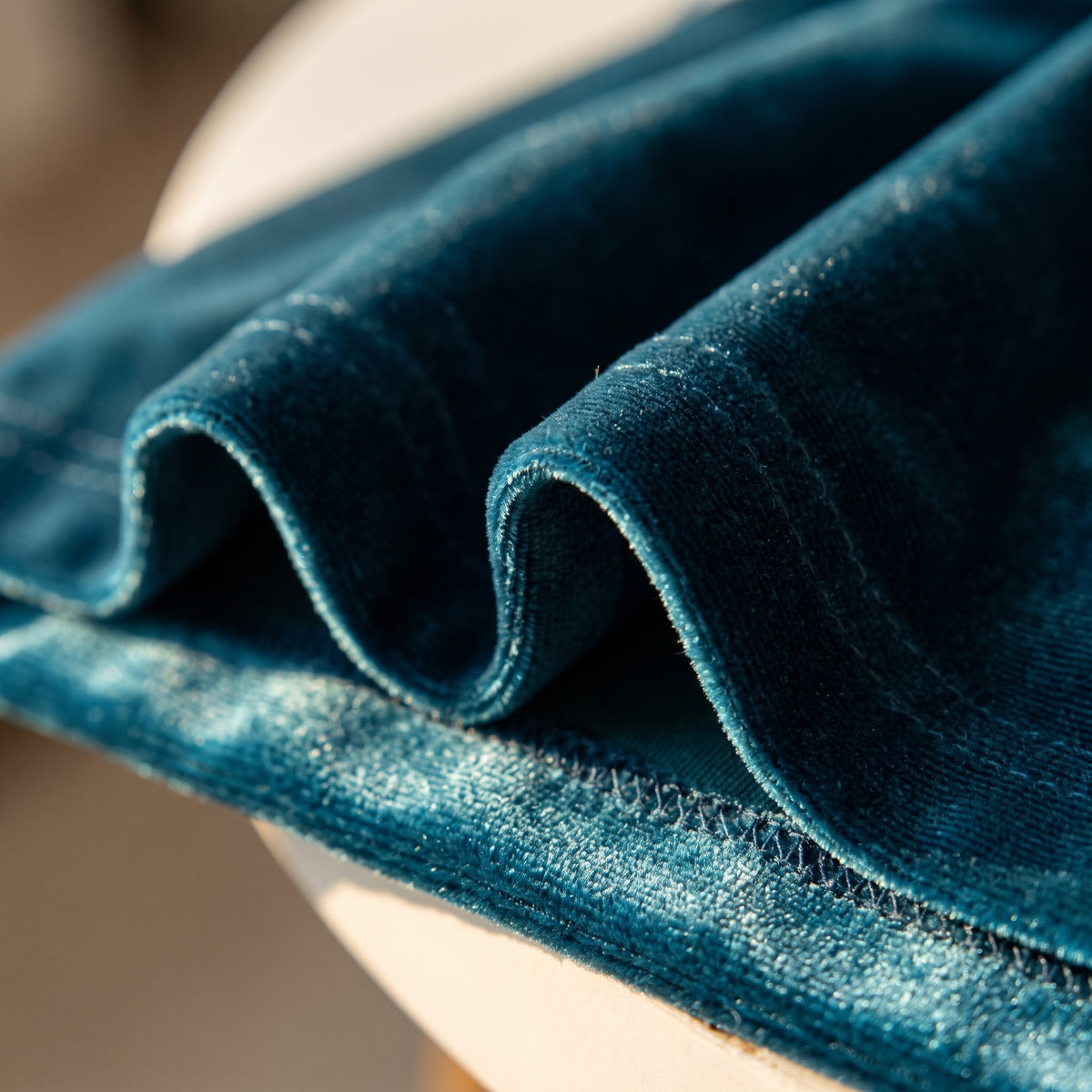 Détail de la maille velours bleu canard et de l'ourlet de l'ensemble.