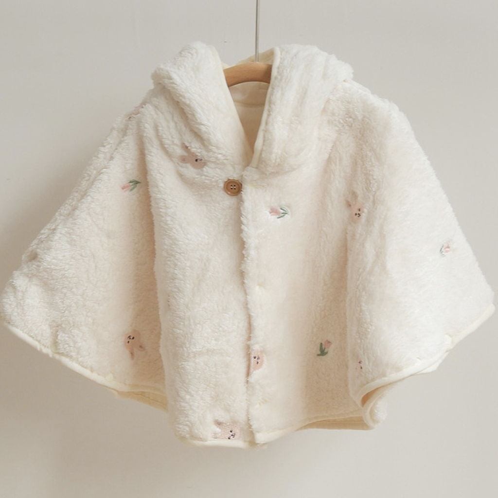 La cape motif lapin rose et tulipes suspendue de face, capuche rabattue derriere l encolure