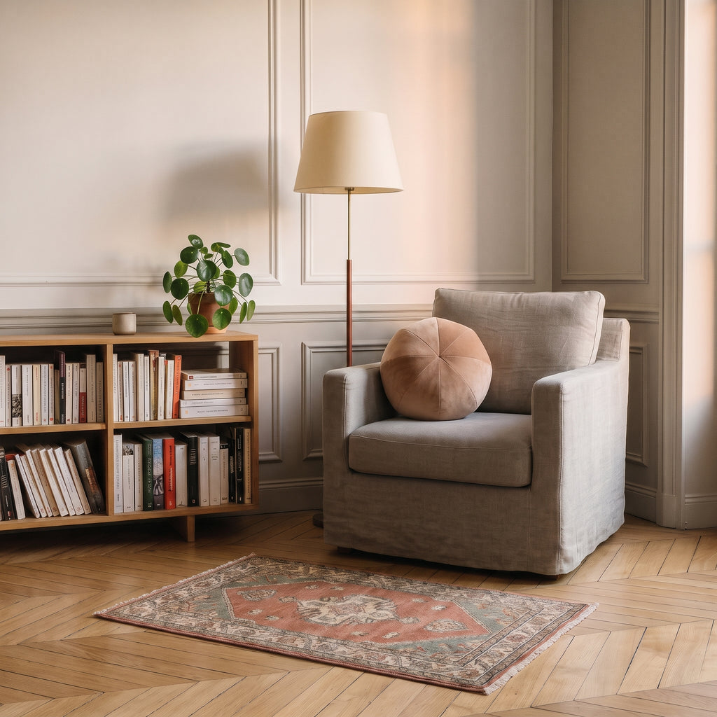 Coussin rond nordique en velours marron clair, posé dans un fauteuil de lecture