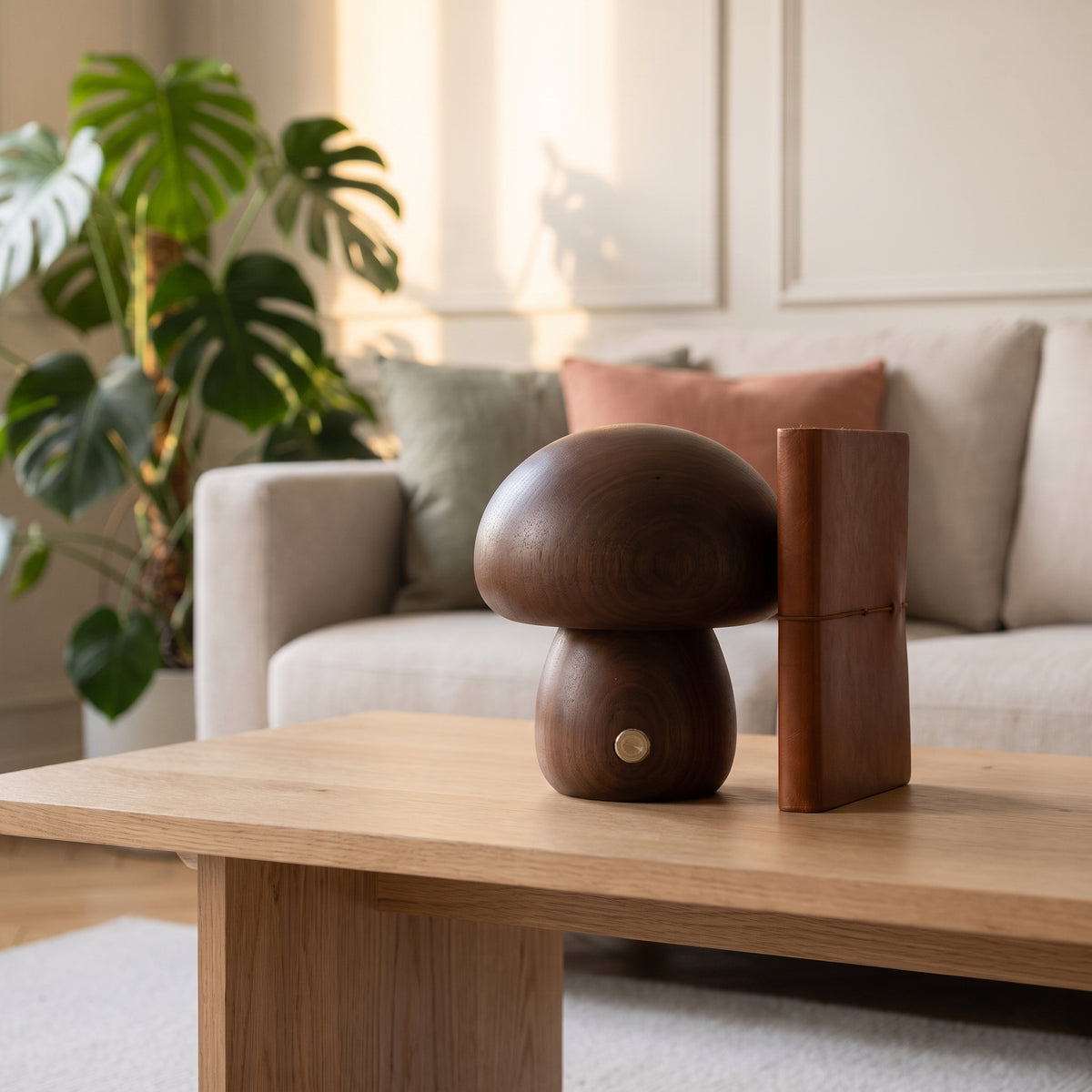 Lampe champignon en bois foncé, petit modèle, posée près d'un carnet sur une table basse