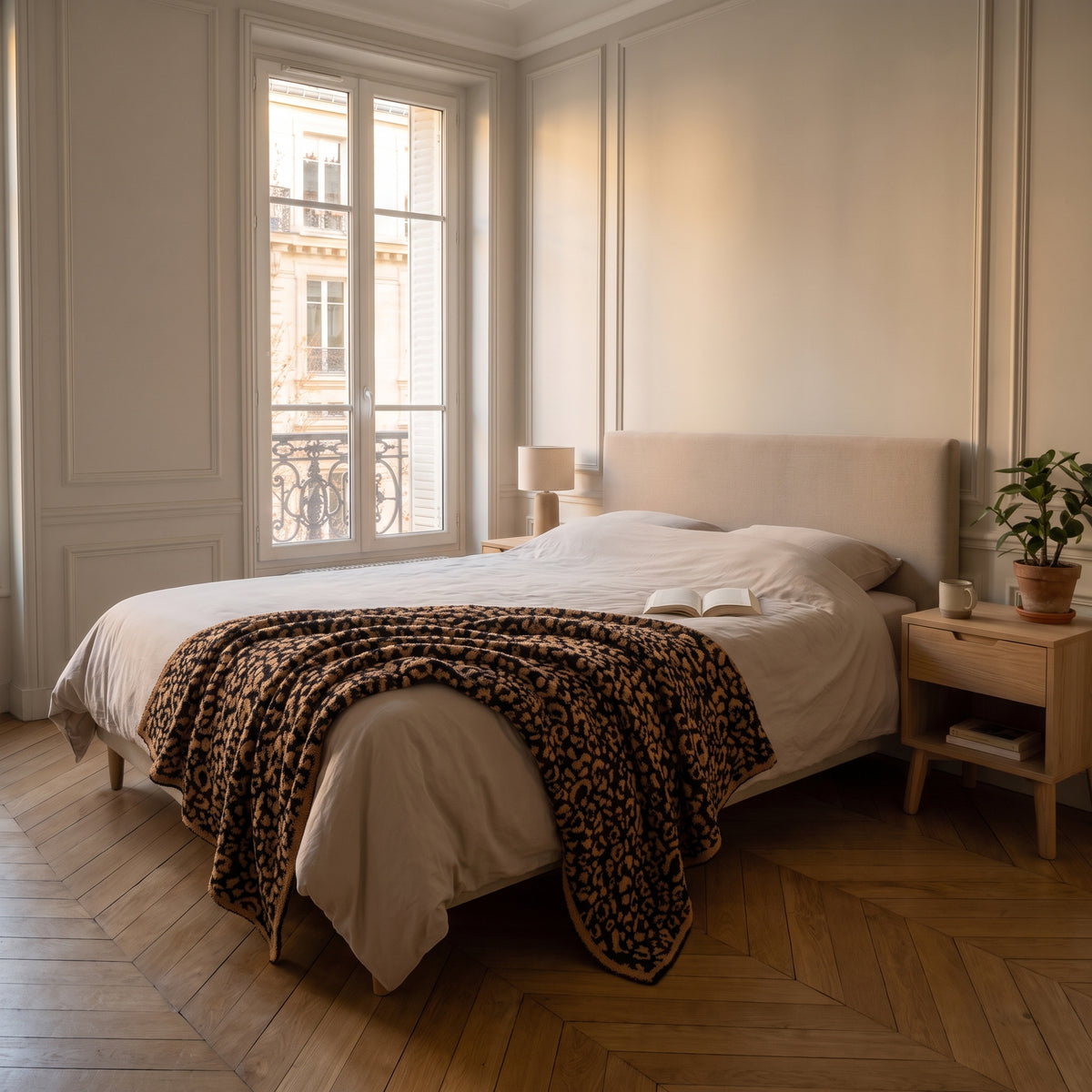 Plaid léopard camel et noir déplié sur un lit deux places