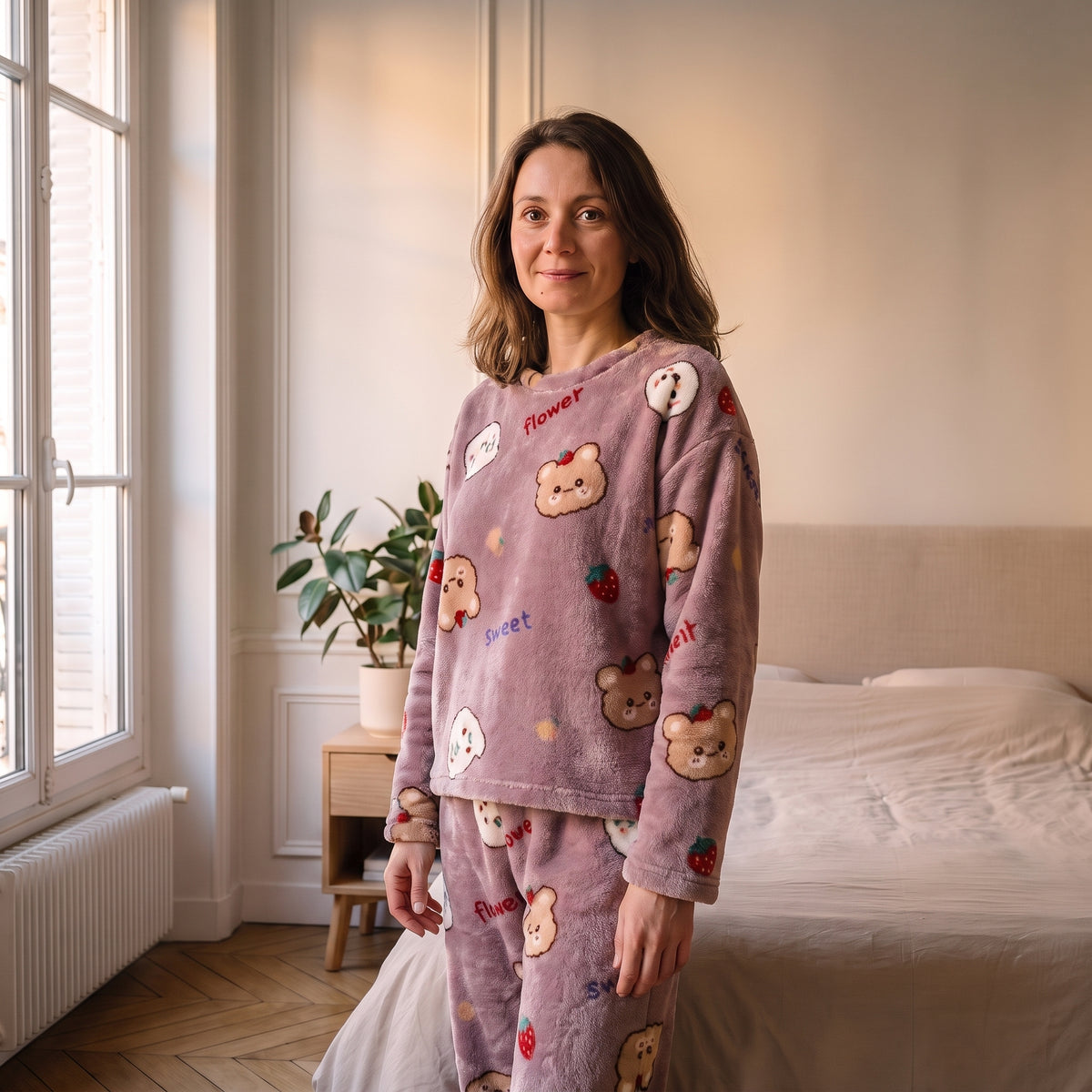 Femme portant le pyjama d'hiver mauve animaux dans une chambre lumineuse