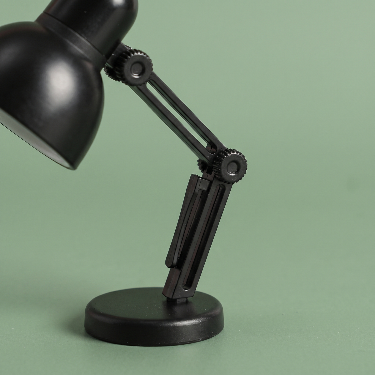 Détail du bras articulé et du socle de la mini lampe de lecture noire