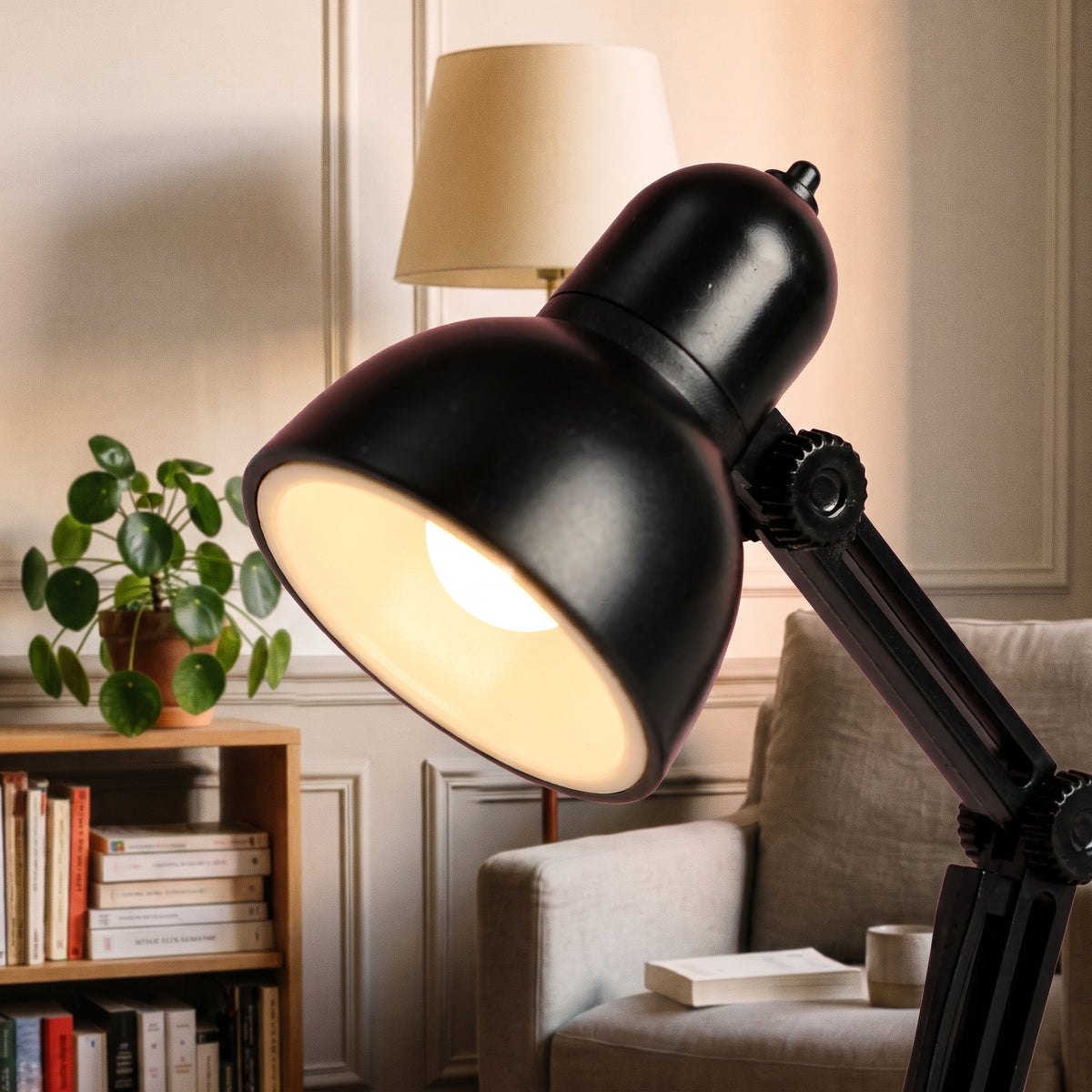 Gros plan sur la tête et l articulation crantée de la mini lampe de lecture noire, LED allumée et petit bouton sur le dessus
