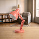 Mini lampe de lecture corail à abat-jour rond posée sur un plan de travail en bois clair, vue de trois quarts