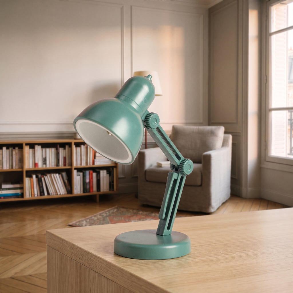Mini lampe de lecture vert sapin à abat-jour rond posée sur un plan de travail en bois clair, vue de trois quarts