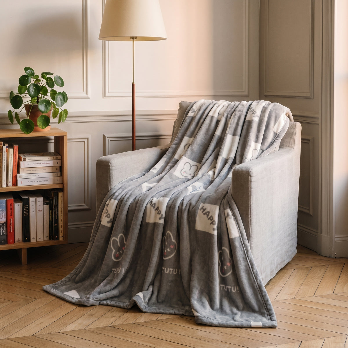 Plaid en peluche, motif Damier gris et lapins, posé sur un fauteuil de lecture