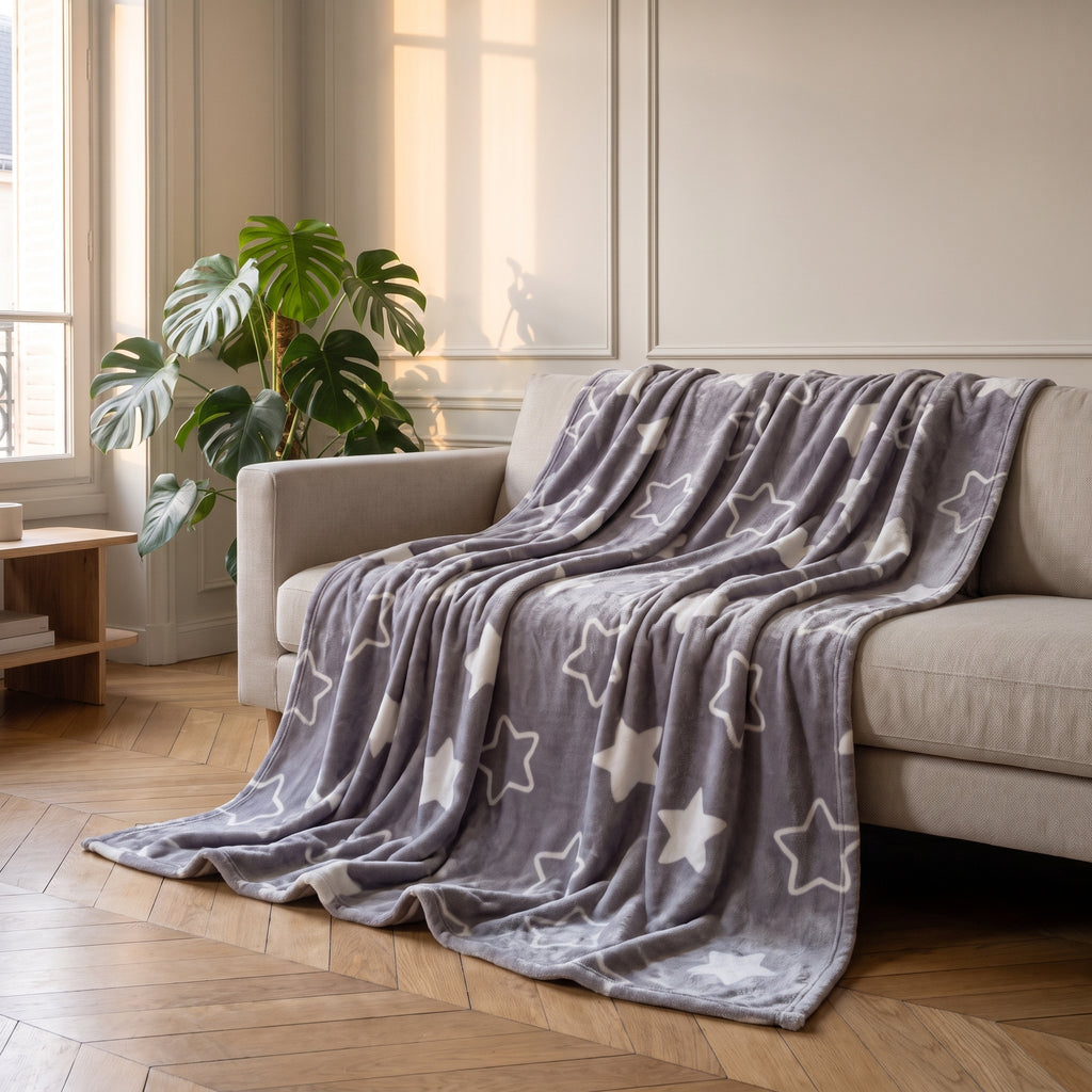 Plaid polaire à motifs, modèle Étoiles lavande, jeté sur un canapé de salon